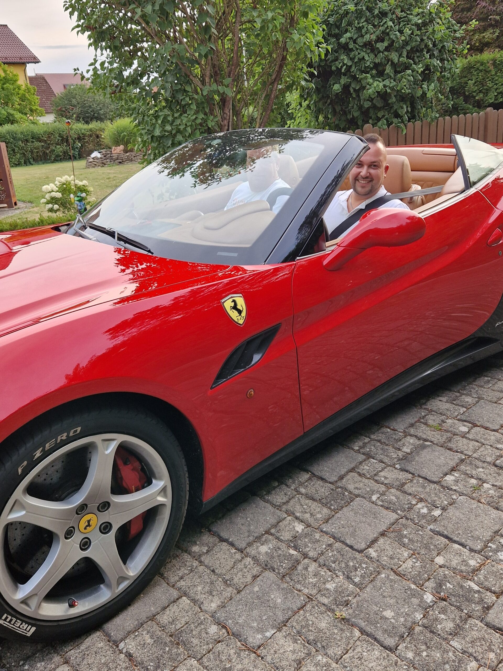 Mann fährt Ferrari California 30 Cabrio und lächelt – echtes Fahrerlebnis